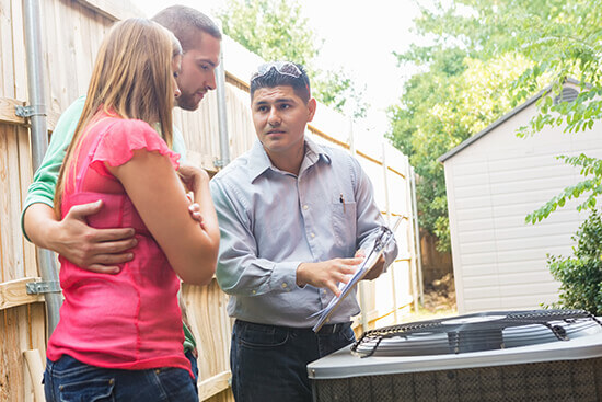 A technician explaining his findings to a couple in Addison