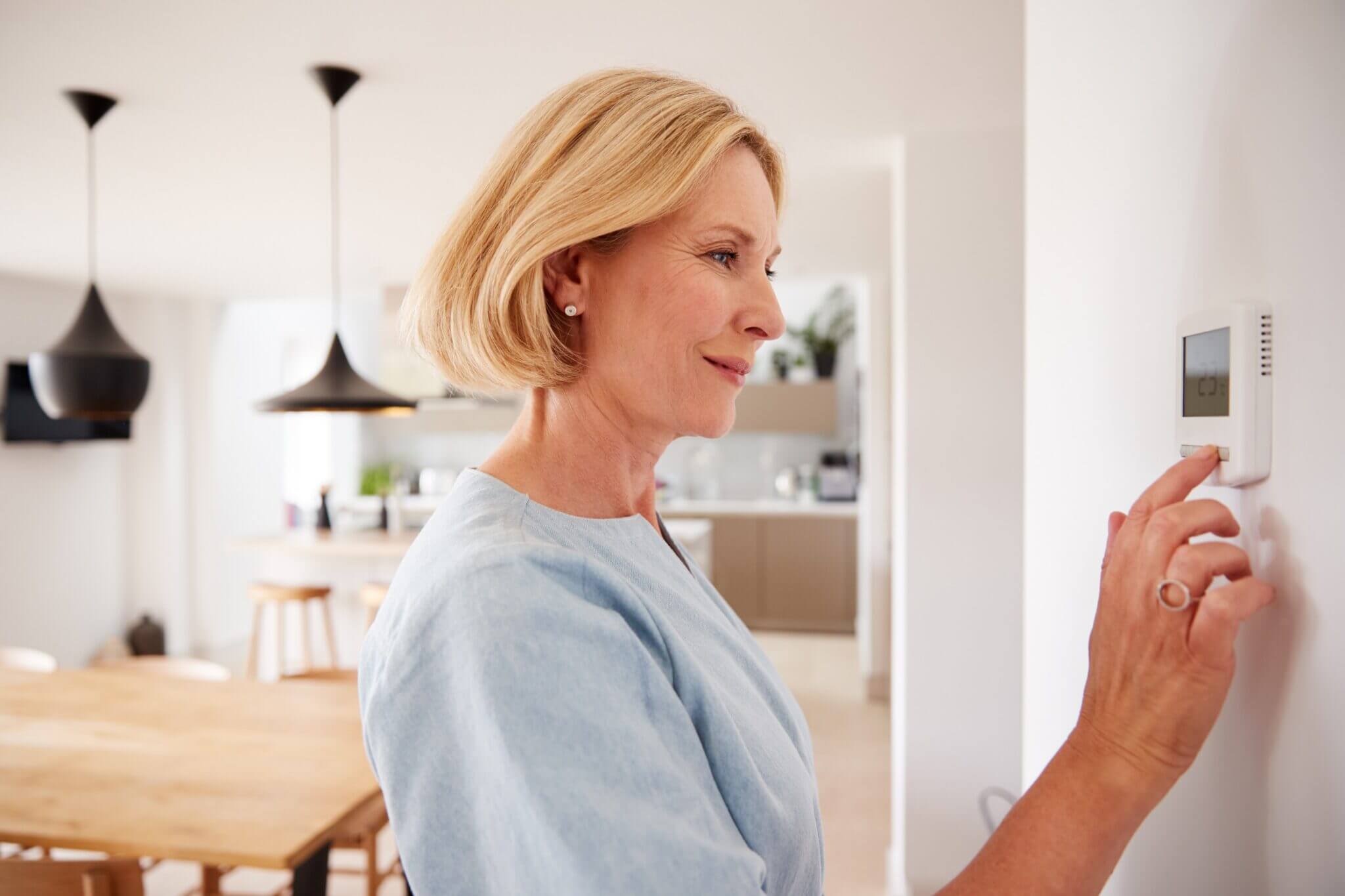 a person adjusting a thermostat Farmers Branch TX